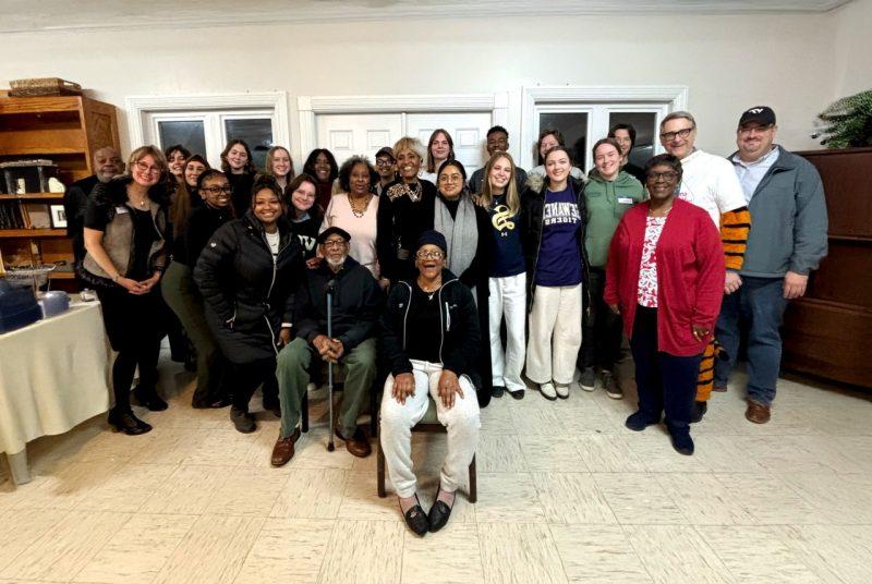 A large group of students and community members pose for a photo.